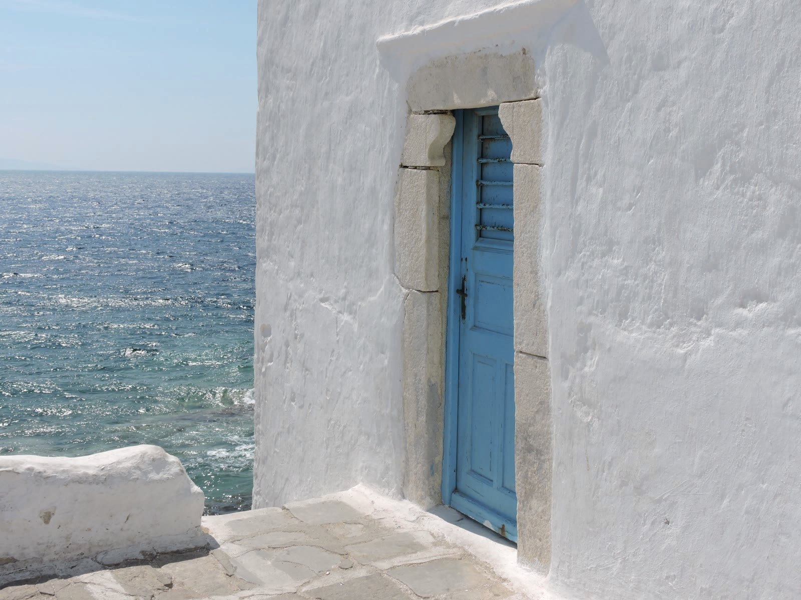 A whitewashed chapel door by the sea