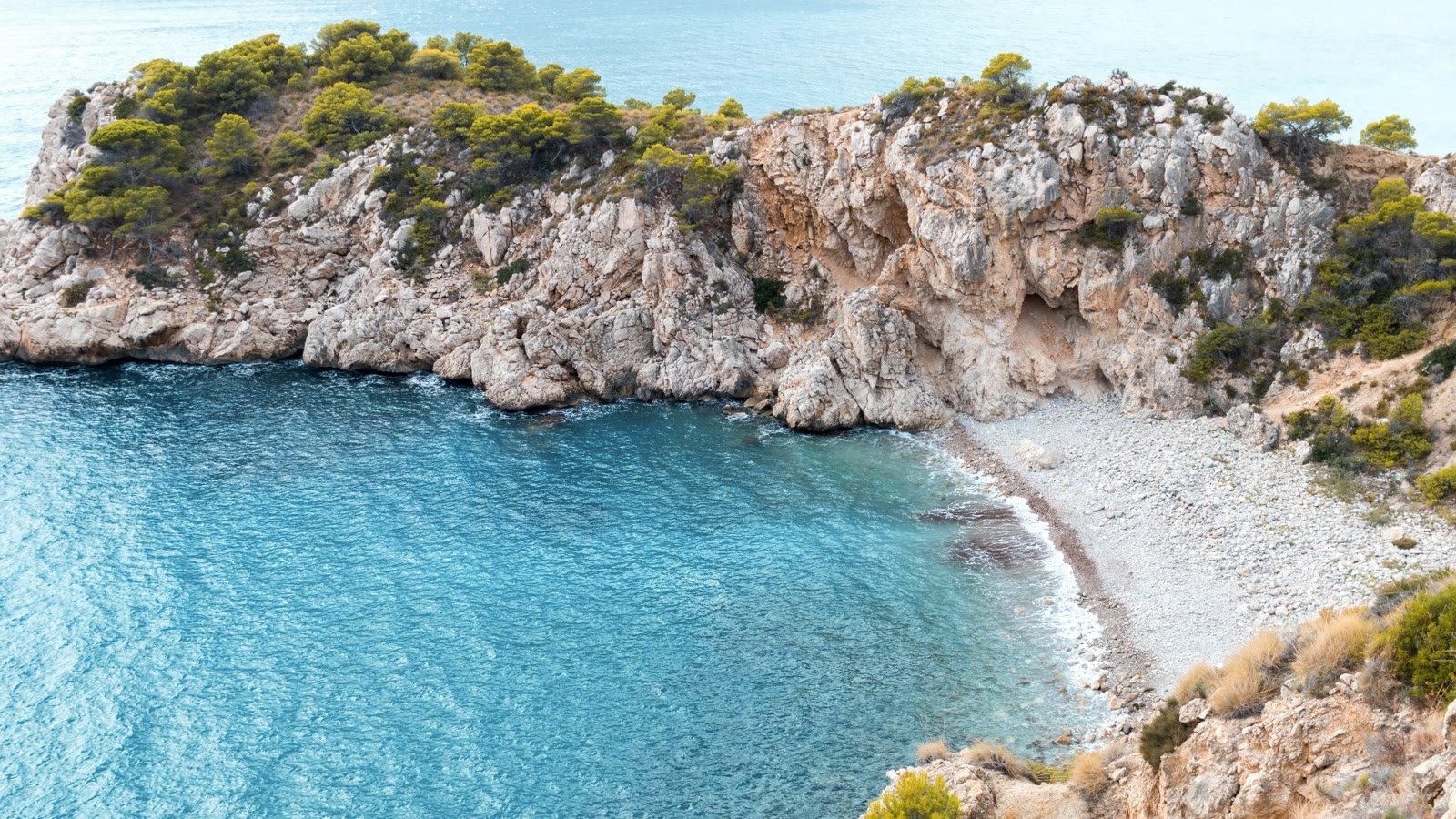 A turquoise cove and pine-clad headland on the Jávea coast